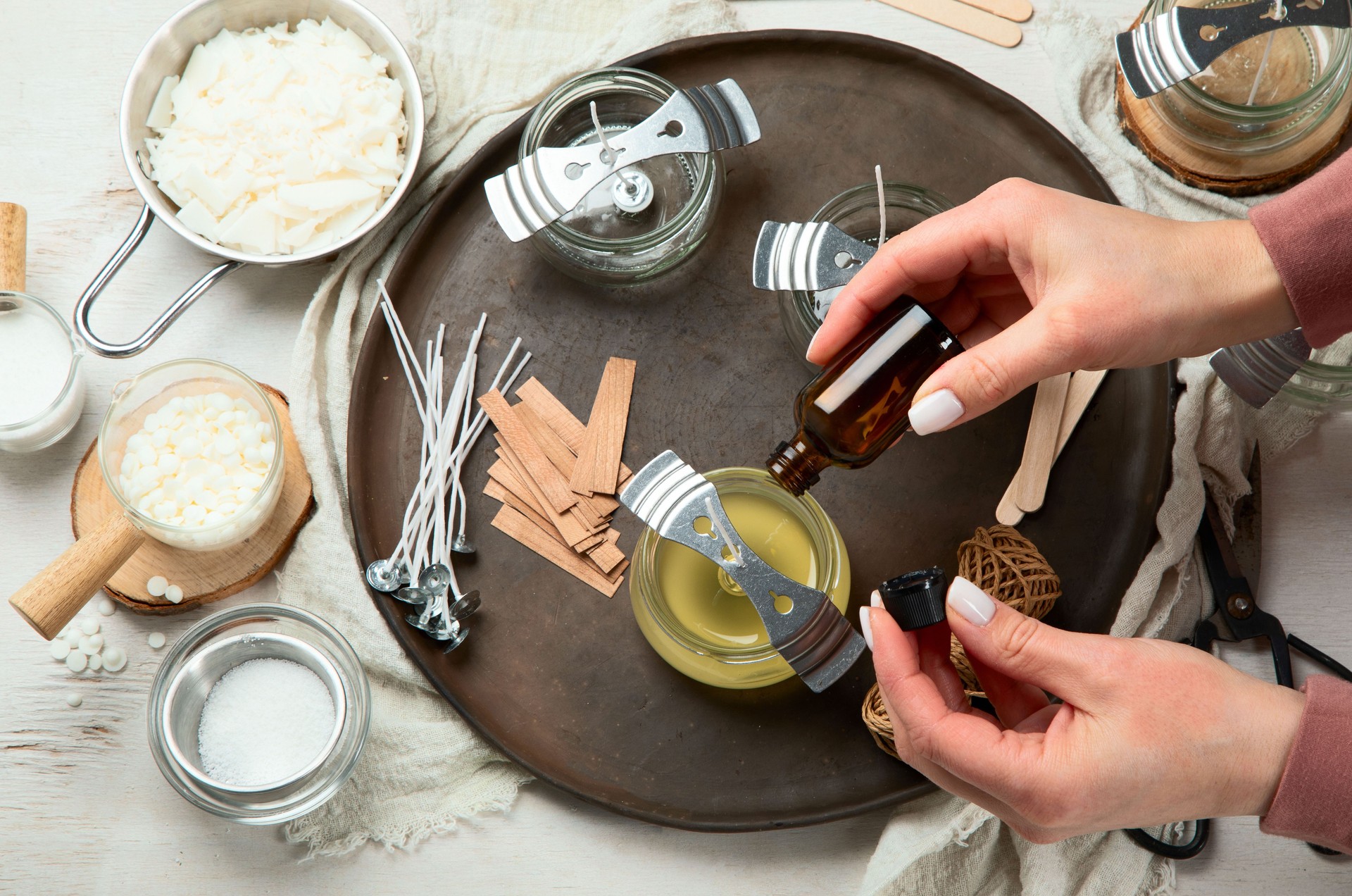Set for homemade natural eco soy wax candles, Woman making decorative aroma candle at table.